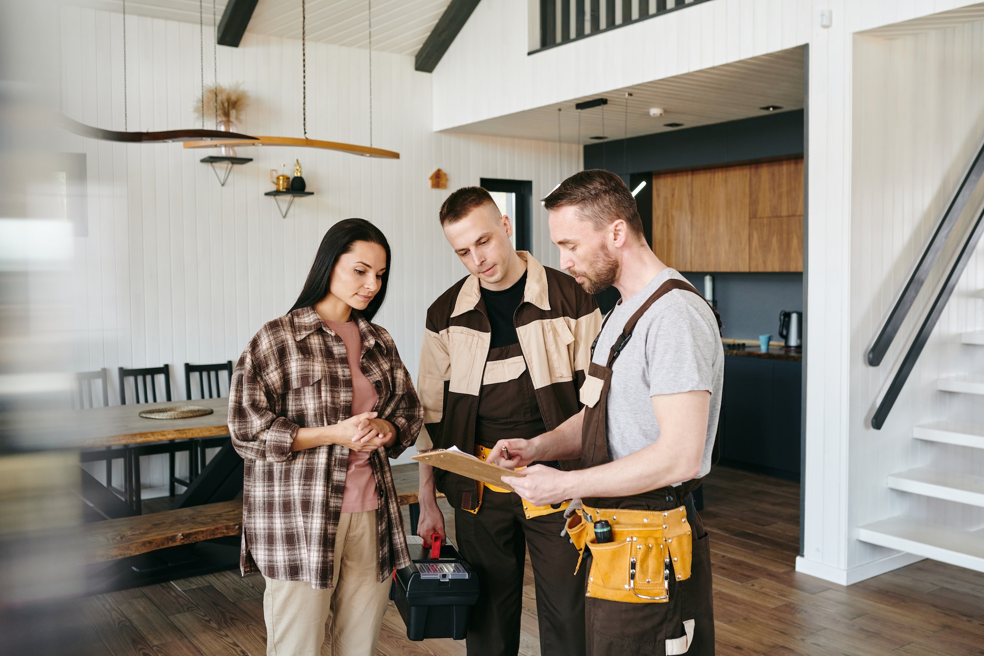 Young plumber giving document to female for her signature