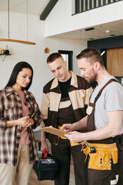 Young plumber giving document to female for her signature